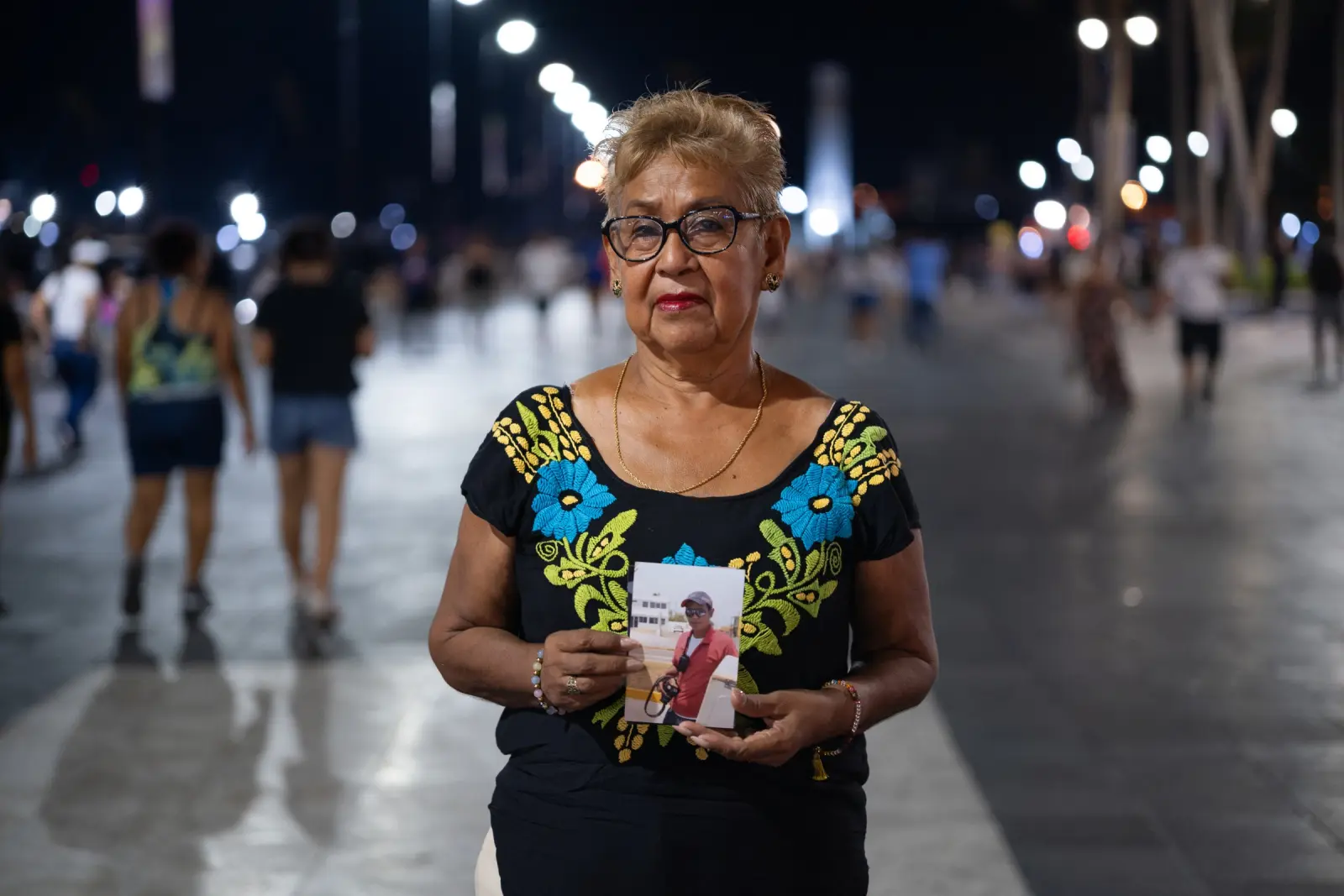 Mujer sostiene la fotografía de un periodista con su cámara